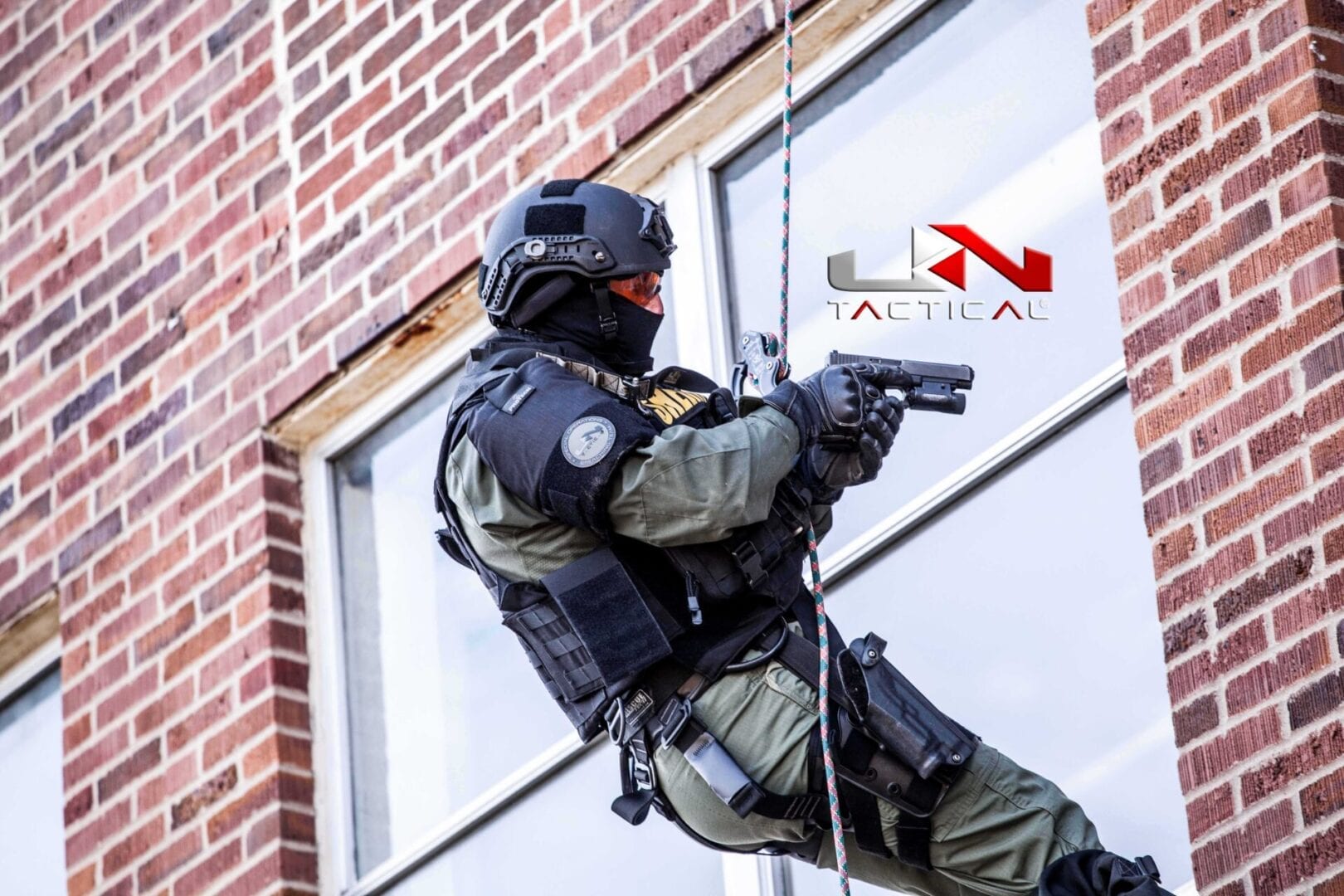 A police officer is climbing a building with a gun.