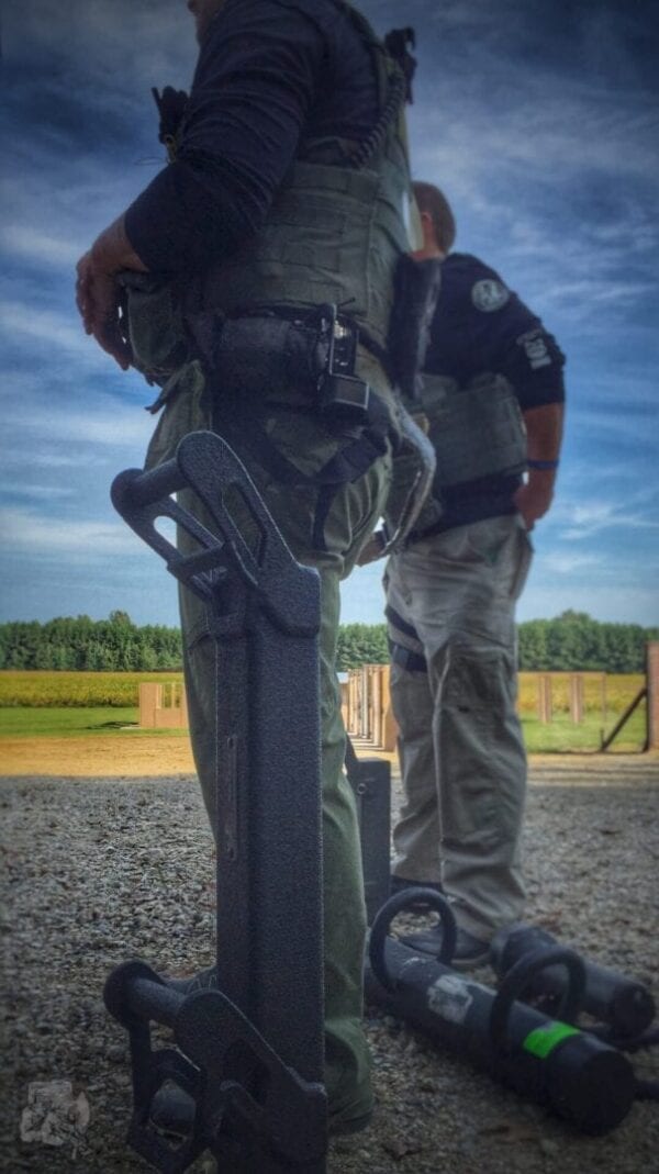 Two TR-1 BREACHING RAM police officers standing next to each other.