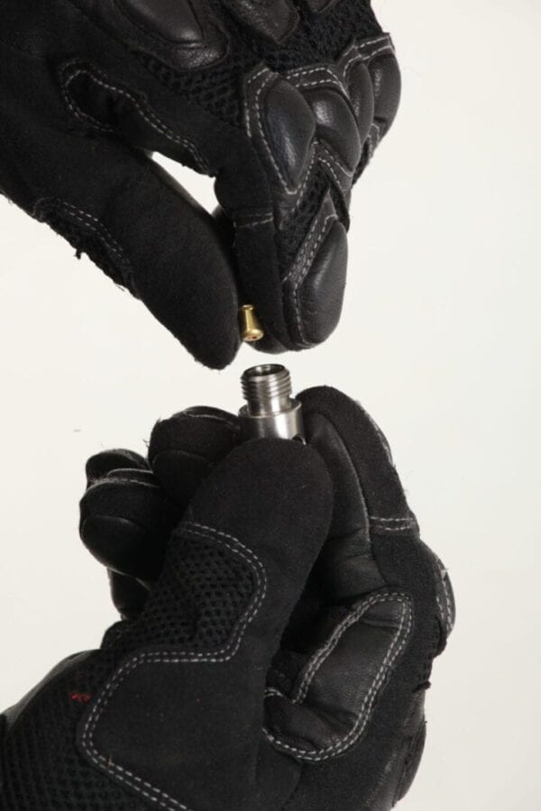 A pair of black gloves holding a nut.