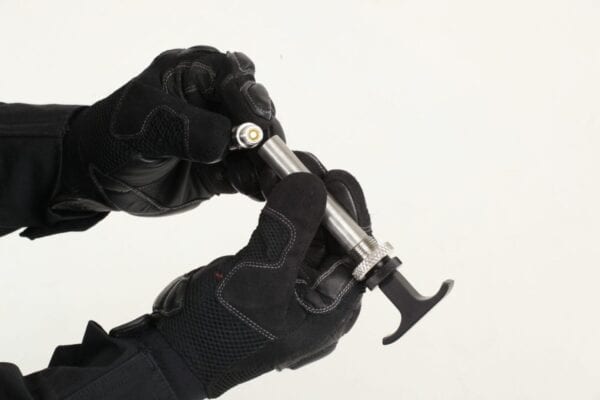 A person in black gloves is holding a tool.
