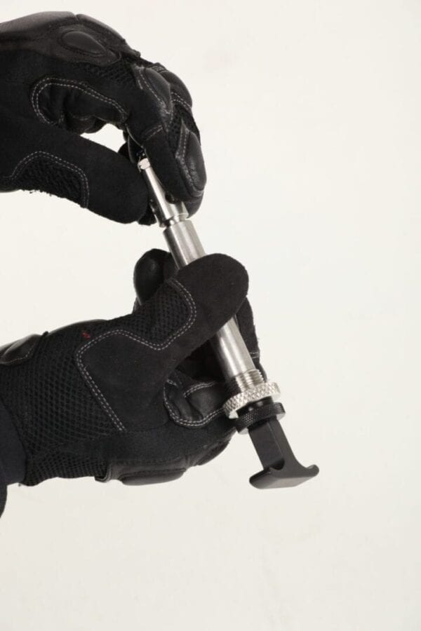 A pair of black gloves holding a tool.