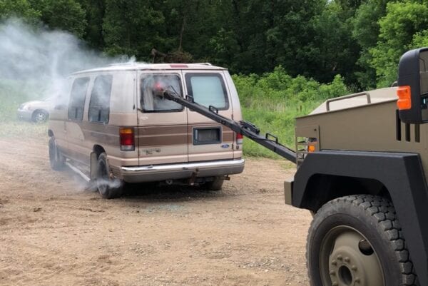 A military vehicle with the DRACO GAS DELIVERY SYSTEM emitting smoke.