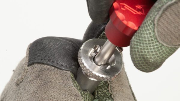 A close up of a DRACO GAS DELIVERY SYSTEM screw on a leather glove.