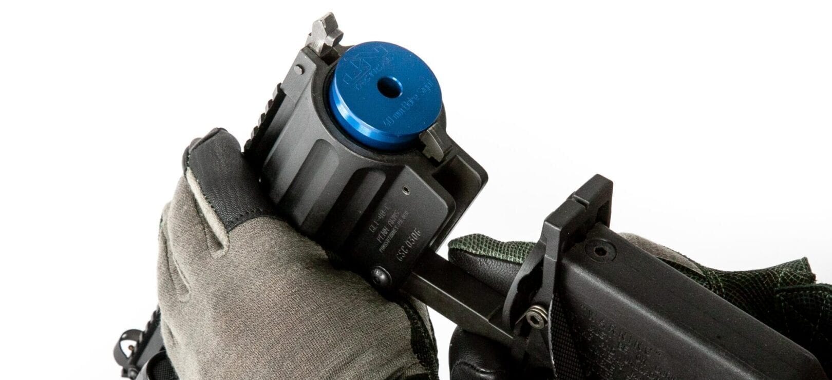 A person holding a gun with a blue button on it.