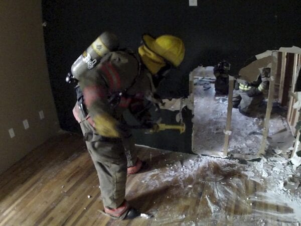 A firefighter is removing a wall with the RIT-3 Tool.