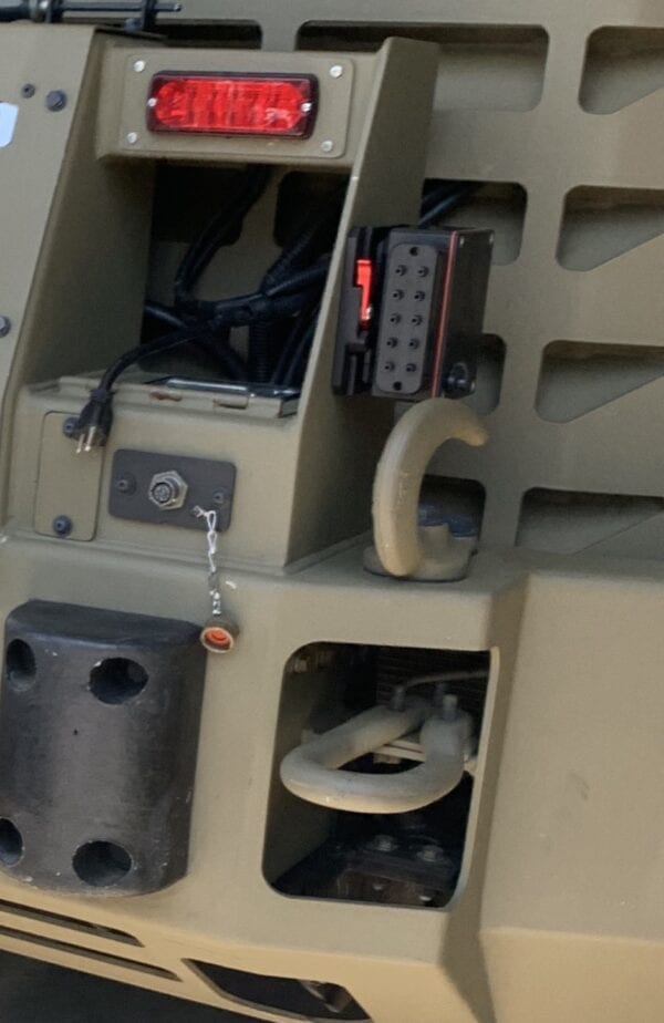 A close up of a DFS-10 - DRACO Wireless Electronic Firing System attached to a military vehicle with a light.